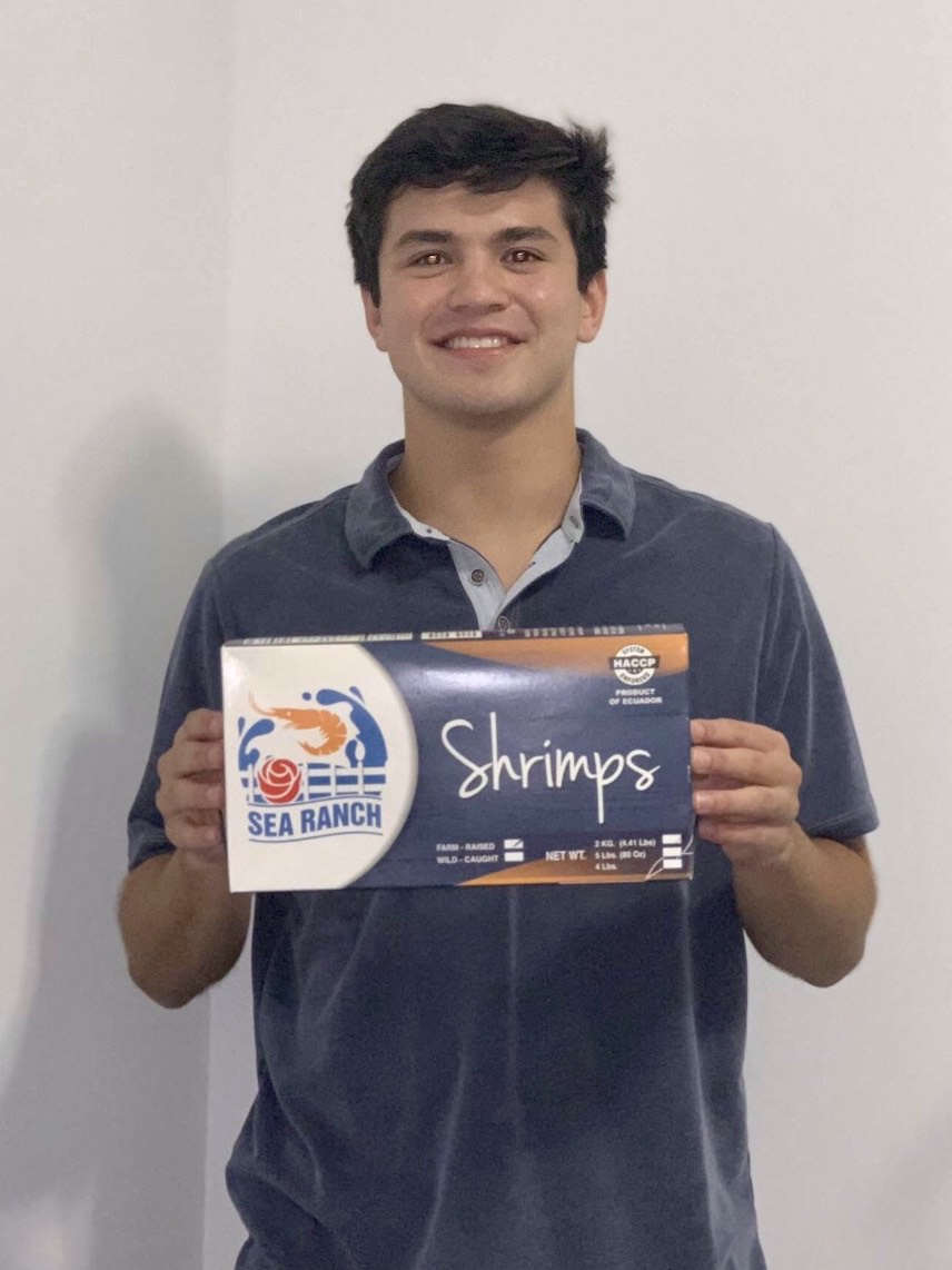 Holding a fresh package of shrimp.